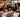 nsurance agency team enjoying a holiday moment together around a desk in a decorated office.